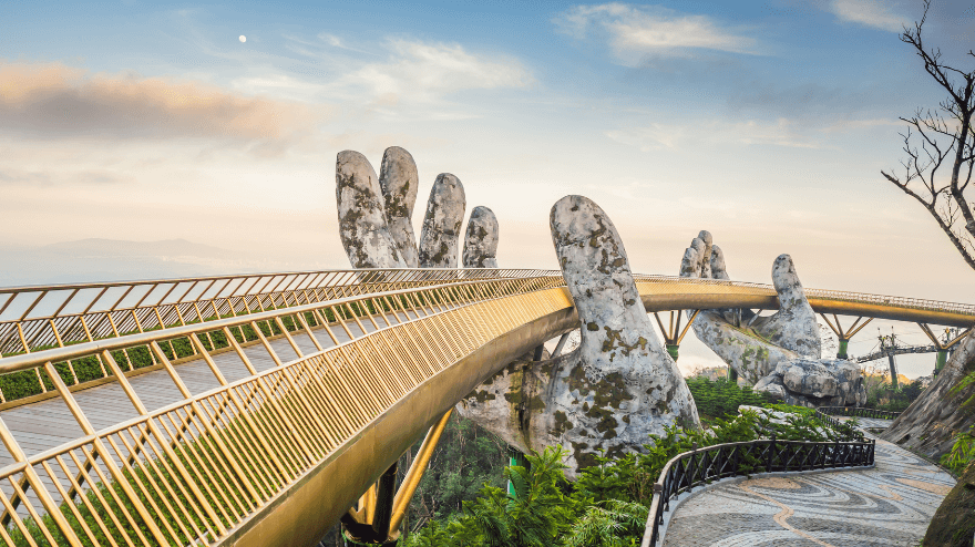 Two giant stone hands hold a golden bridge.