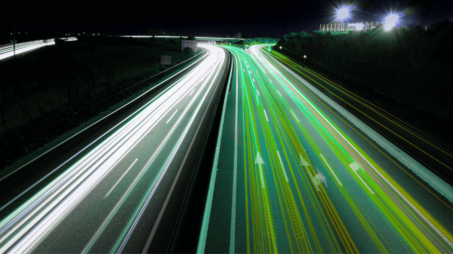 Time-lapse shot of cars and a divided highway at night.